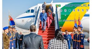 Presidente lula descendo escada do avião com sua esposa